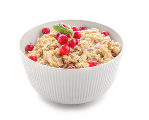 Bowl with tasty oatmeal on white background