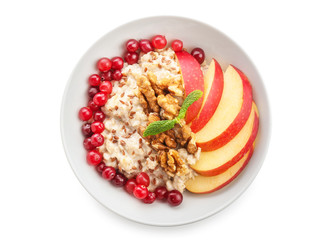 Bowl with tasty oatmeal on white background