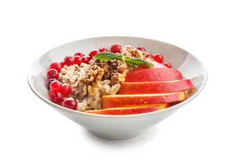 Bowl with tasty oatmeal on white background