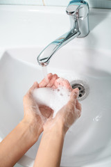 Woman washing hands in sink