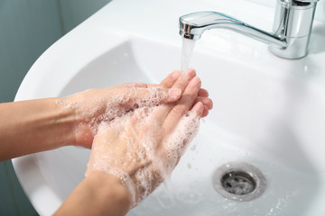 Woman washing hands in sink