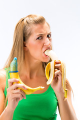 Woman eating banana and showing other banana having condom