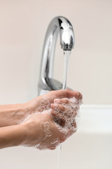 Woman washing hands in sink
