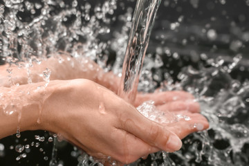 Fototapeta premium Woman washing hands on dark background