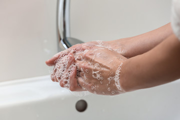 Fototapeta premium Woman washing hands in sink