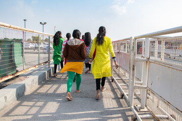 Girls are walking on the pathway in sunny day