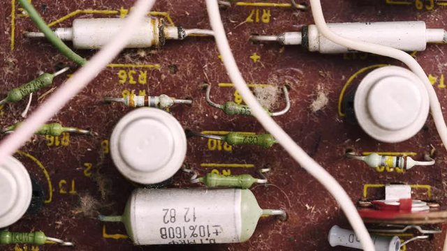 Old dusty microcircuit chip with electronic components. Close-up of resistors, capacitors and wires. Macro shot.