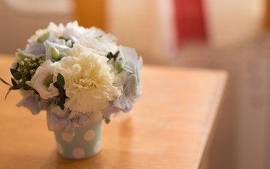 Different flowers in a box on the table near the window, round composition, beautiful gift