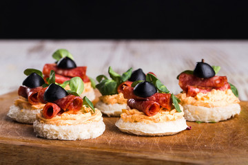 Delicious canapes with salami, olives and spices