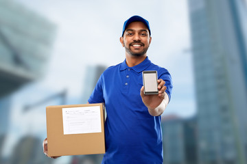 mail service, technology and shipment concept - happy indian delivery man with smartphone and...