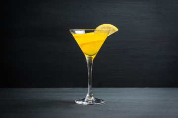 Fresh lemon cocktail in martini glass on the wooden background. Selective focus. Shallow depth of field.