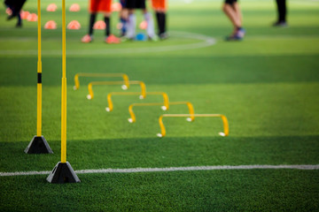 yellow hurdles and ladder drills on green artificial turf