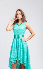 Beautiful young girl in evening turquoise dress, posing, looking at camera. Beautiful long hair, hairstyle, model