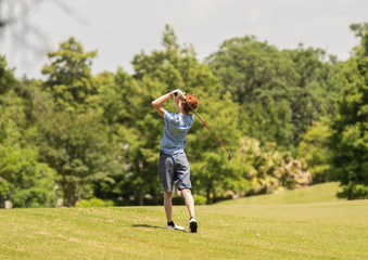unknown student golfer practices his swing for the tournament