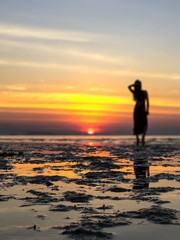 Fototapeta na wymiar Silhouette Woman On Beach Against Sky During Sunset