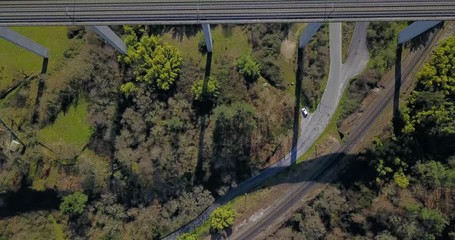FLYING ABOVE THE TRAIN BRIDGE IN A GREEN VALLEY