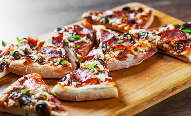 Pizza with Mozzarella cheese, salami, pepper, pepperoni, olives, Spices and mushroom. Italian pizza on wooden table background