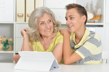 Portrait of grandson and grandmother using tablert