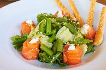 Salad with salmon, asparagus and melted cheese. sprinkled with sesame