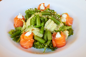 Salad with salmon, asparagus and melted cheese. sprinkled with sesame