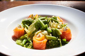 Salad with salmon, asparagus and melted cheese. sprinkled with sesame