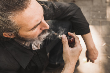 Bearded brutal man smoking pipe