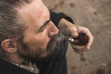 Brutal bearded man smoking pipe