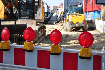 Die Straßenvollsperrung wegen Straßensanierung beim Straßenbau, eine Großbaustelle mit Absperrung in der Stadt Bremen. Warnleuchten mit Schrankenzaun und Straßenbaustelle mit Baumaschinen.