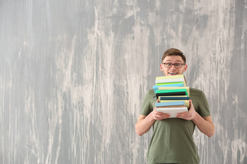 Handsome young man with books on grunge background