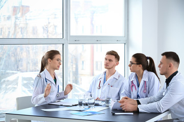Fototapeta premium Team of doctors discussing diagnosis at table in clinic