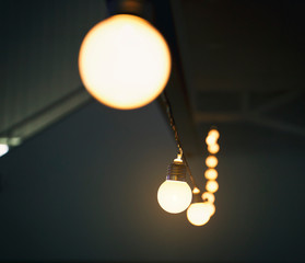 A lot of white lamps on the wire in the concert hall