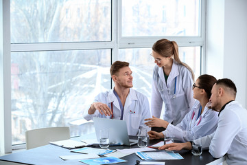 Team of doctors discussing diagnosis at table in clinic