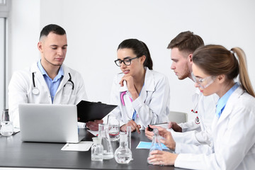 Interns conducting experiment with flasks in clinic