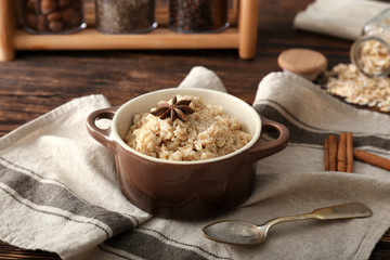 Pot with tasty oatmeal on table