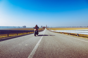 biker in action riding on the road - spring and summer outdoors leisure season and freedom concept-  toned with a trendy filter