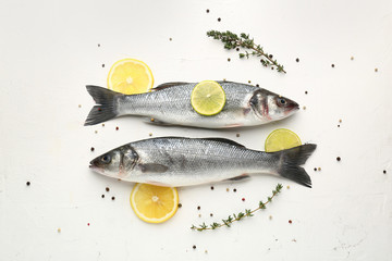 Tasty fresh seabass fish with spices on white background - obrazy, fototapety, plakaty