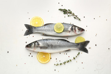 Tasty fresh seabass fish with spices on white background