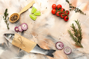 Frame made of raw seabass fish and products on color background