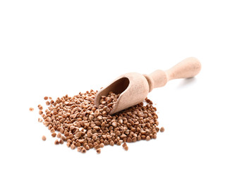 Wooden scoop and raw buckwheat on white background