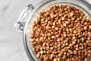 Glass jar with raw buckwheat, closeup