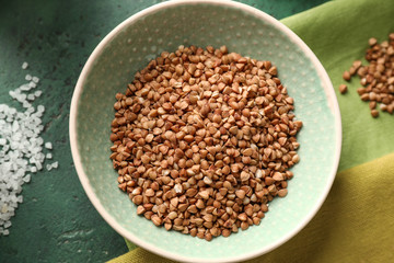 Bowl with raw buckwheat on table