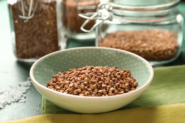 Bowl with raw buckwheat on table