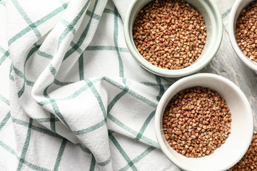 Bowls with raw buckwheat on table