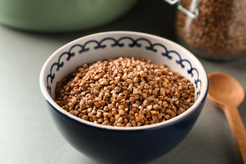 Bowl with raw buckwheat on table