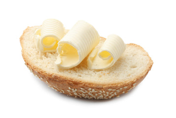 Slice of bread with butter curls on white background