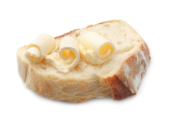 Slice of bread with butter curls on white background
