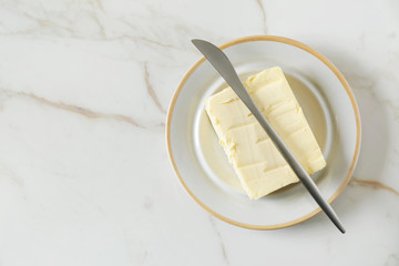 Plate with butter and knife on table - obrazy, fototapety, plakaty
