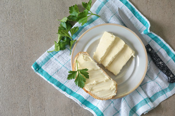 Piece of tasty bread with butter on plate