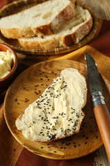 Tasty piece of bread with butter on plate