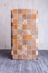 A tile with patterns of brown color on a gray wooden background